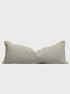 Textured beige lumbar pillow with frayed edges for luxury sofa or bed styling