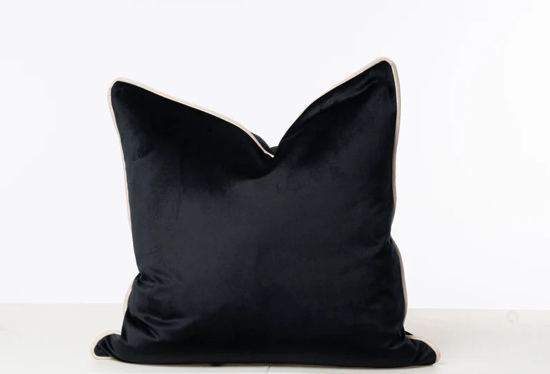 Luxury black velvet cushion with cream piping, perfect for modern sofas and beds