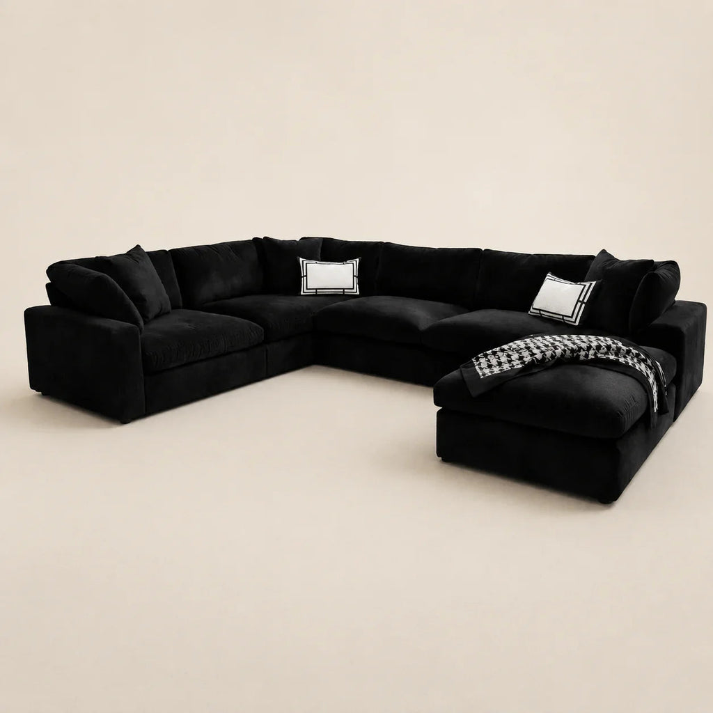 Black velvet sectional sofa with chaise, white accent pillows, and houndstooth throw blanket