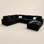 Black velvet sectional sofa with chaise, white accent pillows, and houndstooth throw blanket