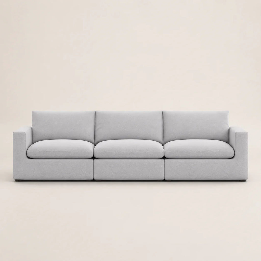 Modern light gray three-seater sofa with clean lines and plush cushions, ideal for luxury living rooms