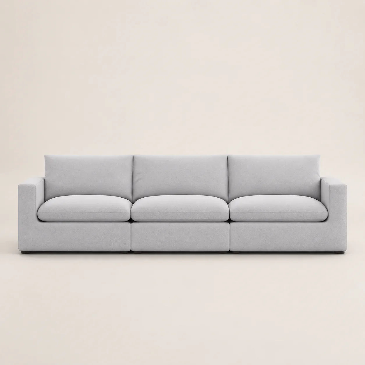 Modern light gray three-seater sofa with clean lines and plush cushions, ideal for luxury living rooms