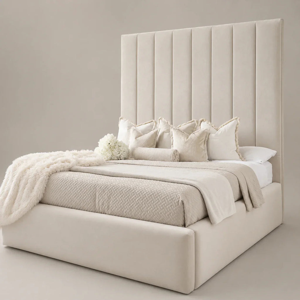 Luxury beige upholstered bed with tall tufted headboard, plush pillows, and cozy throws for modern bedroom decor