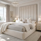 Luxury beige upholstered bed with tufted headboard, plush pillows, and crystal chandelier in elegant bedroom