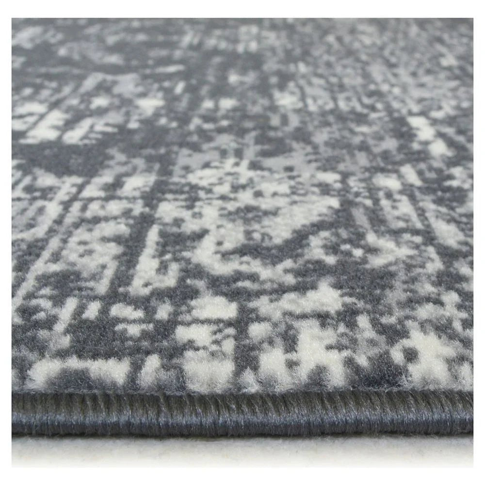 Grey and white distressed pattern area rug with plush texture and bound edge