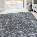 Grey and white abstract patterned area rug in modern living room with sofa and doorway