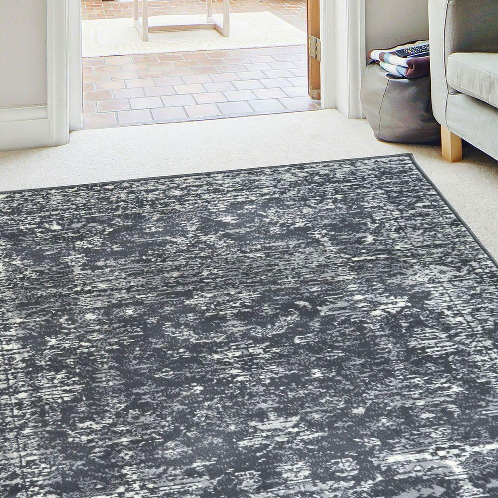 Grey and white abstract patterned area rug in modern living room with sofa and doorway