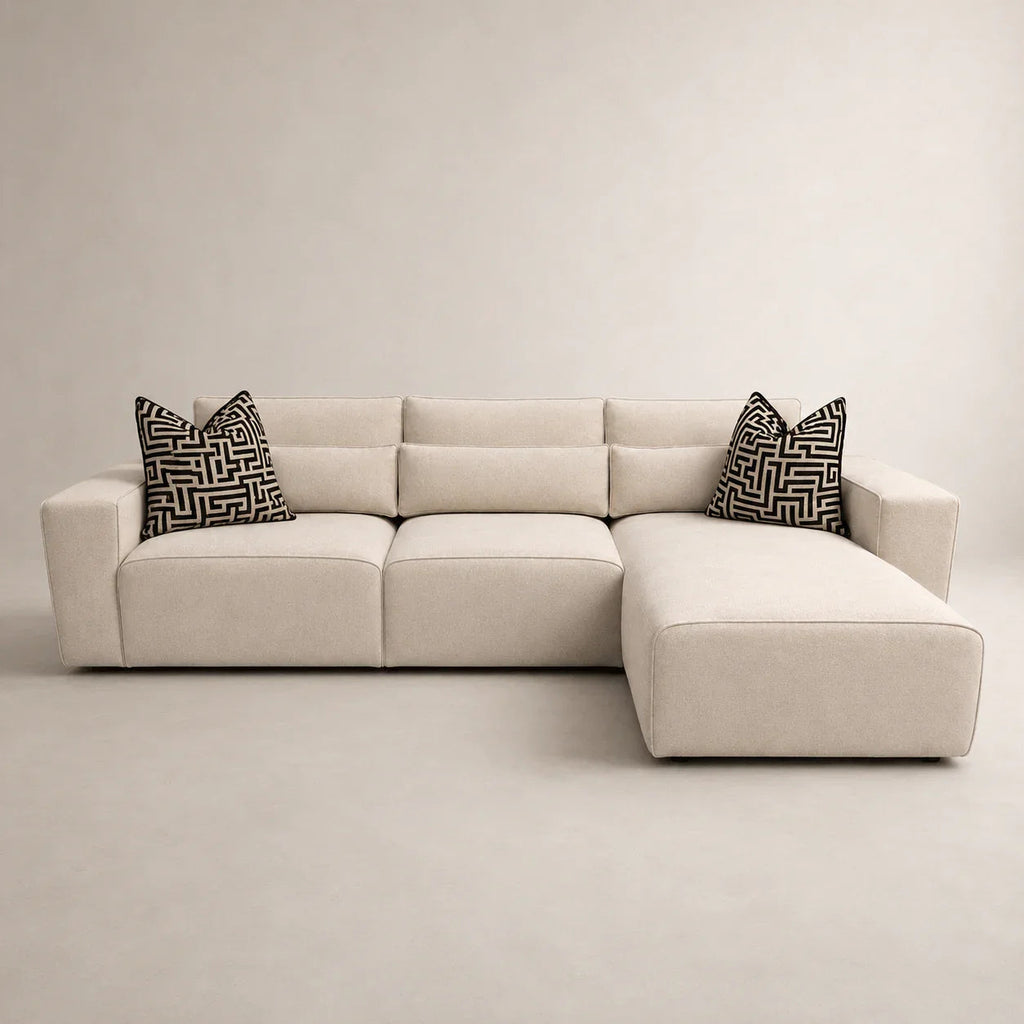 Beige L-shaped sectional sofa with geometric black and white pillows, modern luxury living room furniture