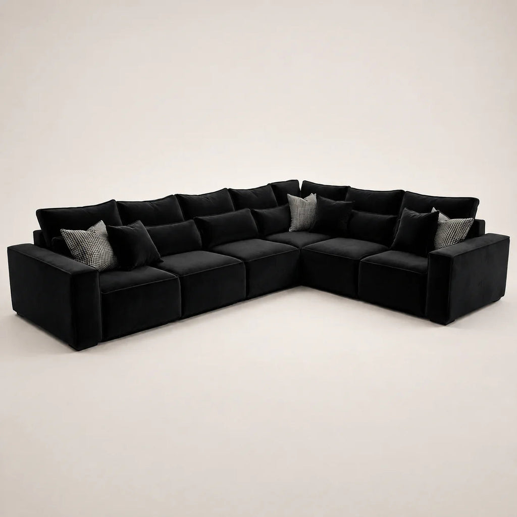 Black velvet L-shaped sectional sofa with patterned throw pillows, luxury living room furniture
