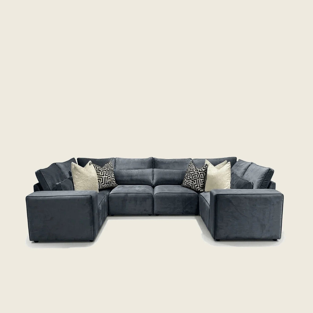 Luxury dark grey sectional sofa with geometric and cream throw pillows, ideal for modern living rooms.