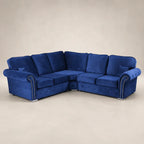 Luxury blue velvet corner sofa with tufted detailing and nailhead trim, perfect for modern living rooms.