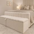 Cream bouclé storage bench at foot of luxury bed, matching headboard and bedding for cozy bedroom