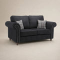 Dark grey fabric sofa with rolled arms, nailhead trim, and plaid pillows for living room comfort