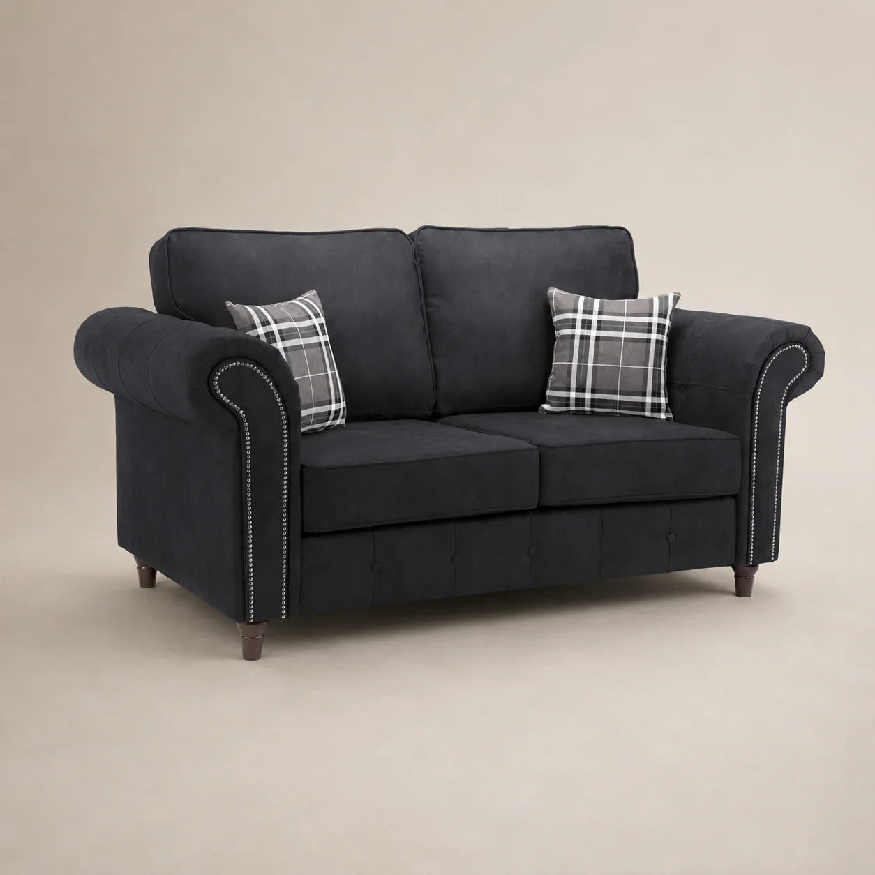 Dark grey fabric sofa with rolled arms, nailhead trim, and plaid pillows for living room comfort