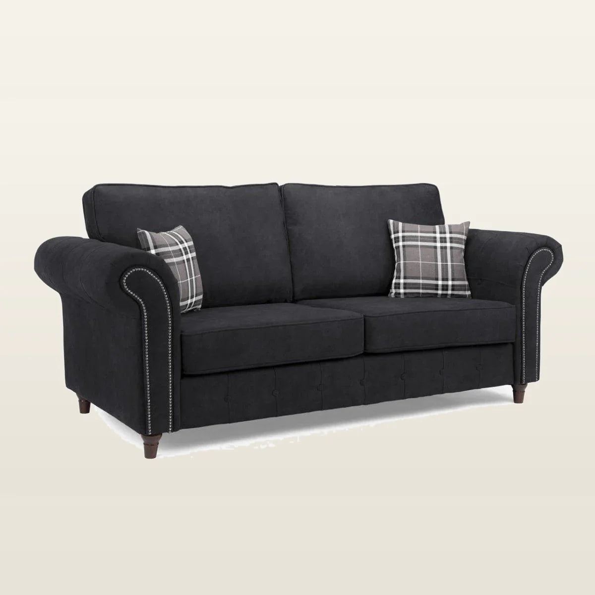 Black fabric sofa with rolled arms, nailhead trim, and plaid pillows for living room comfort
