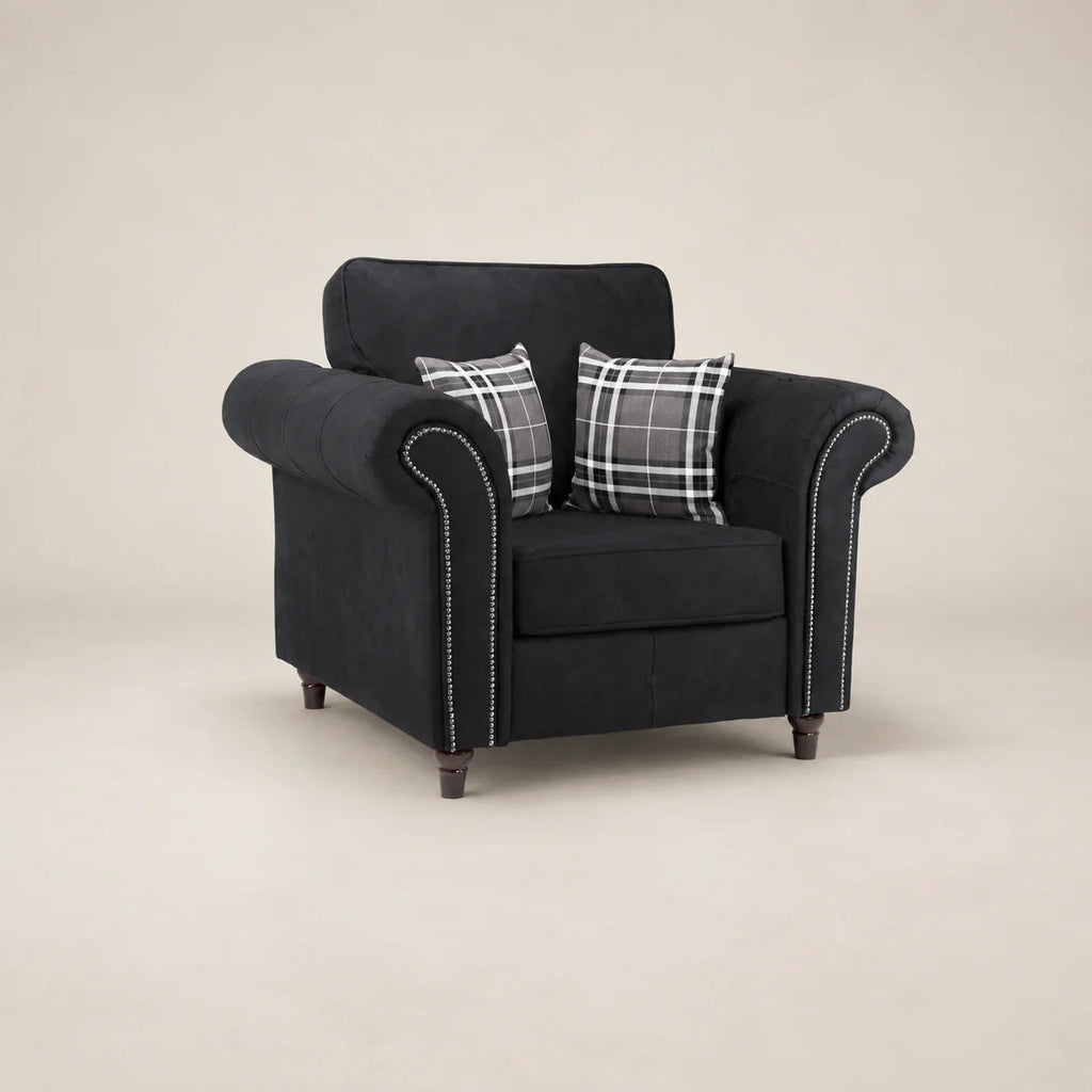 Black fabric armchair with rolled arms, nailhead trim, and plaid pillows for luxury living room seating