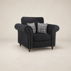 Black fabric armchair with rolled arms, nailhead trim, and plaid pillows for luxury living room seating