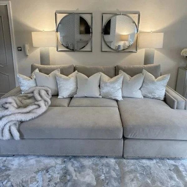 Mink velvet corner sofa with stud detailing, white throw pillows, and faux fur blanket in modern living room