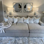 Mink velvet corner sofa with stud detailing, white throw pillows, and faux fur blanket in modern living room