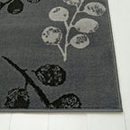 Gray area rug with floral pattern, soft texture, placed on white wood floor for modern home decor