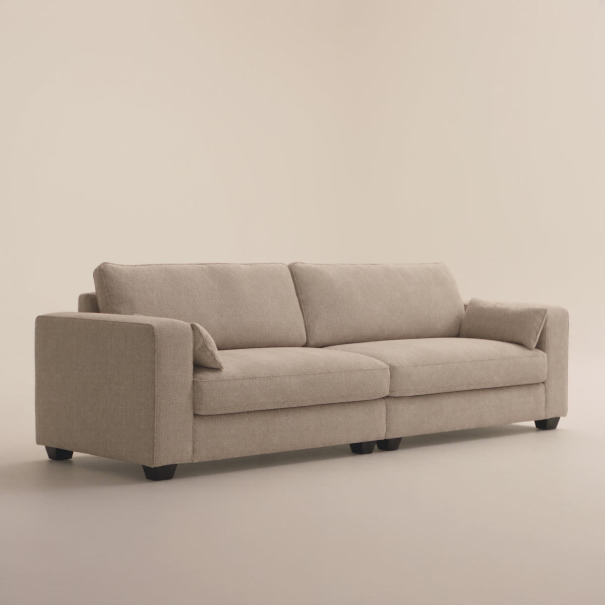 Verdi XL Sofa in Summer Beach — full sofa studio demonstration with model entering from the left and sitting naturally for scale