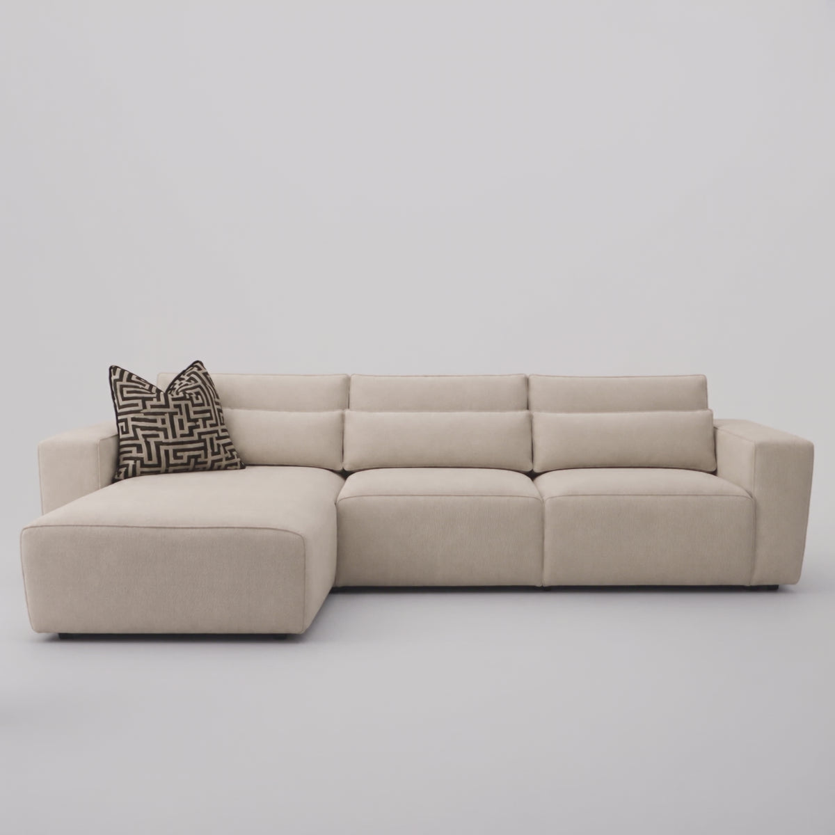Maison 3 Seater Chaise Sofa in a minimal studio with an adult model demonstrating scale