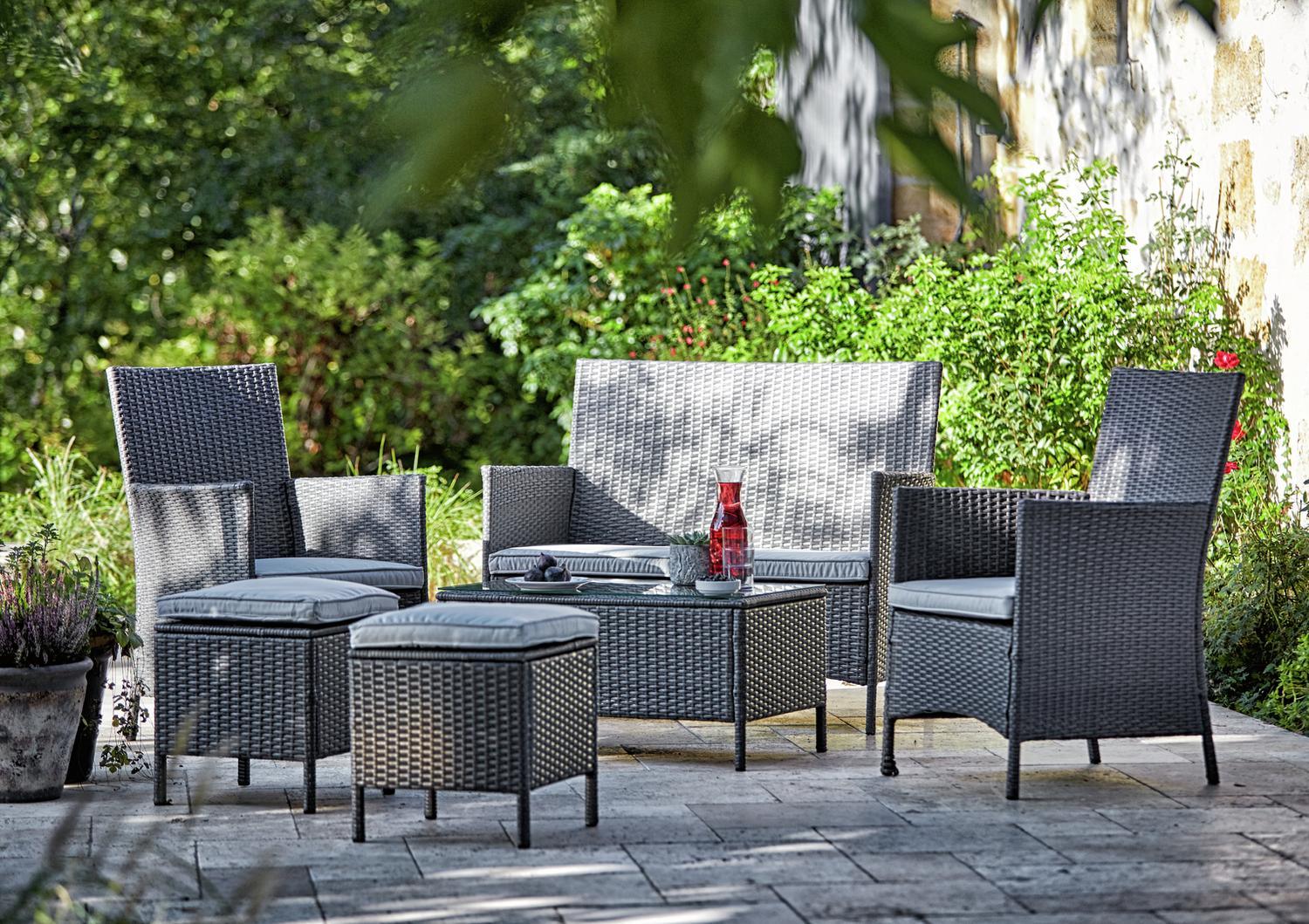 Grey wicker outdoor sofa set with cushions on patio, perfect for garden relaxation