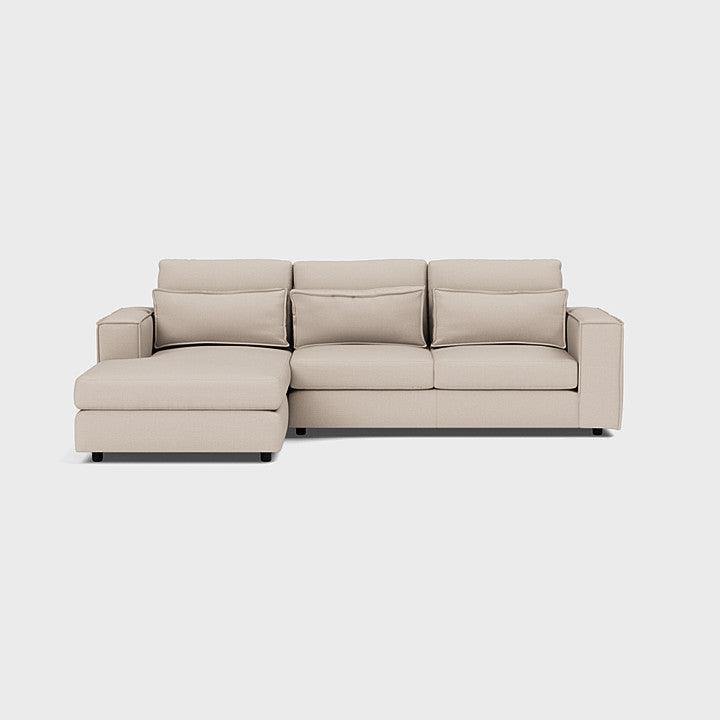 Modern beige corner chaise sofa with wide armrests and plush cushions on a white background