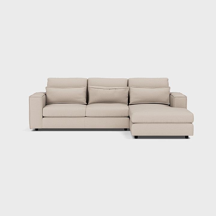 Modern beige corner chaise sofa with plush cushions on a plain background