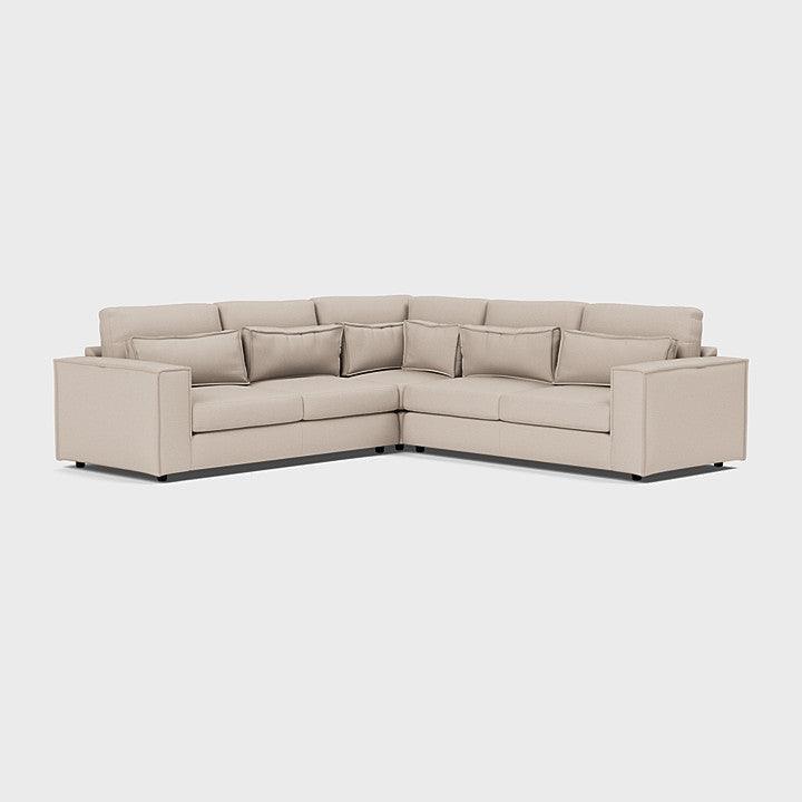 Modern beige double corner sofa with clean lines and plush back cushions on white background