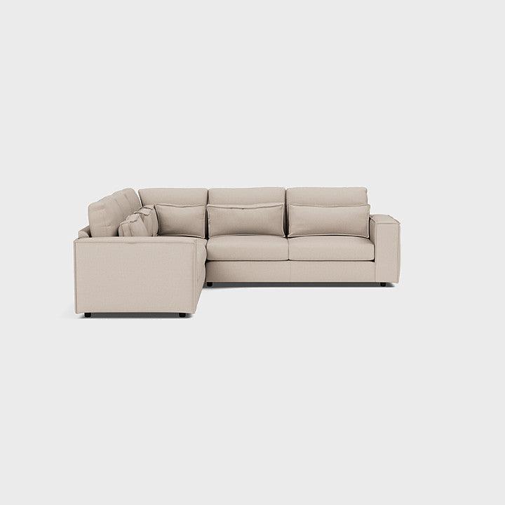 Modern beige double corner sofa with deep cushions on a white background