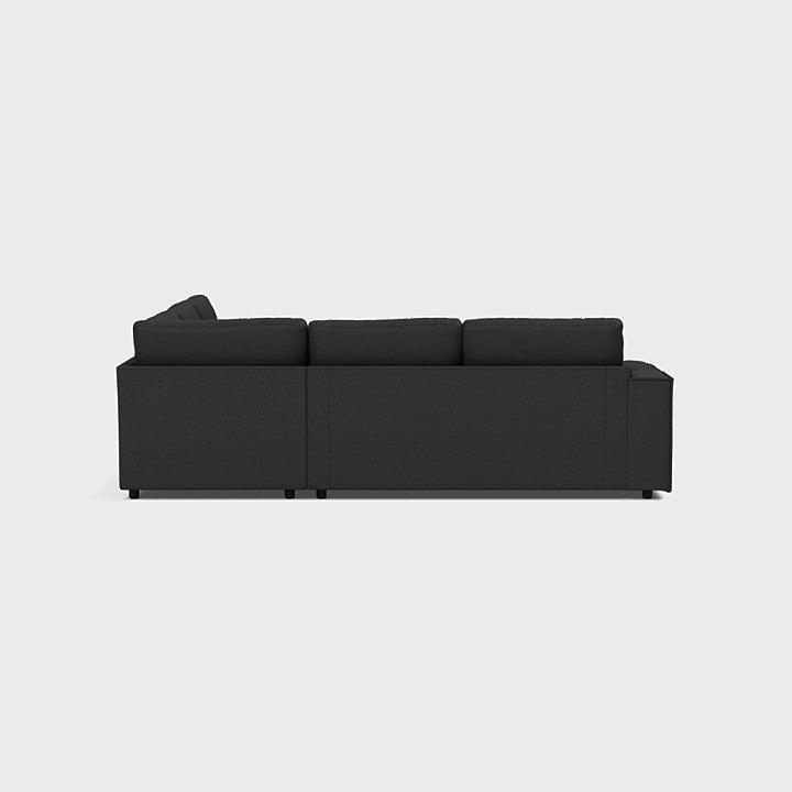 Modern dark grey double corner sofa with clean lines, viewed from the back on white background