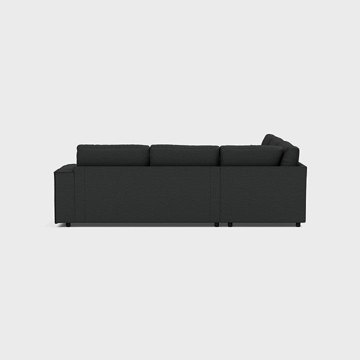 Modern dark grey double corner sofa with clean lines, photographed from side view on white background