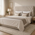 Luxury upholstered bed with tufted headboard, neutral bedding, and modern bedside table in bright bedroom