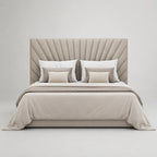Luxury upholstered bed with tufted headboard, neutral bedding, and striped accent pillows