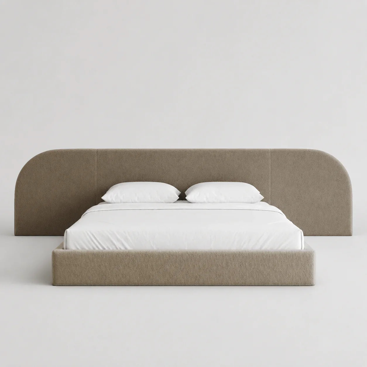 Modern upholstered bed with curved headboard, white linens, luxury bedroom furniture