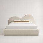 Luxury upholstered bed with curved headboard, white bedding, and beige textured fabric