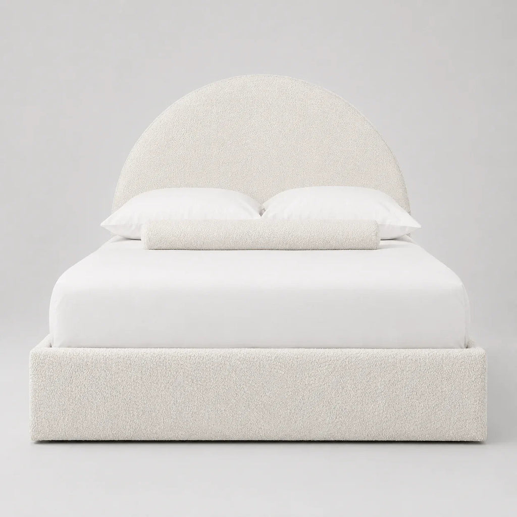 Luxury upholstered bed with curved headboard, white bedding, and textured fabric for modern bedroom