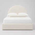 Luxury upholstered bed with curved headboard, white bedding, and textured fabric for modern bedroom