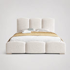 Luxury upholstered bed with segmented headboard and footboard, white bedding, gold throw