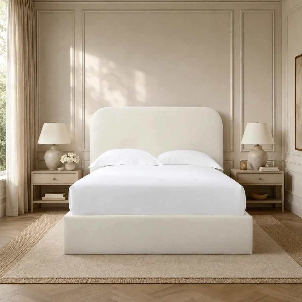 Luxury upholstered bed with white linens in elegant bedroom, featuring panelled walls and matching nightstands