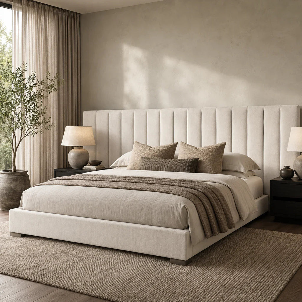 Luxury upholstered bed with tufted headboard, neutral bedding, and modern bedside lamps in a serene bedroom.