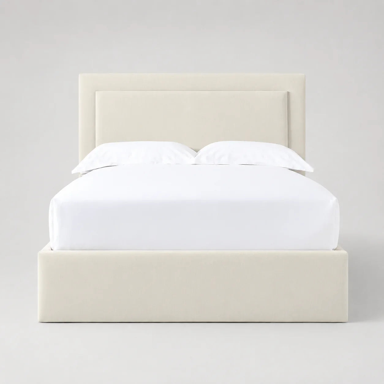 Cream upholstered bed frame with white linens, modern luxury bedroom furniture