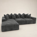 Dark gray sectional sofa with chaise and plush pillows, modern luxury living room furniture