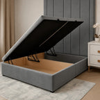 Grey upholstered storage bed with lift-up mechanism, showing spacious wooden interior, ideal for luxury bedrooms.