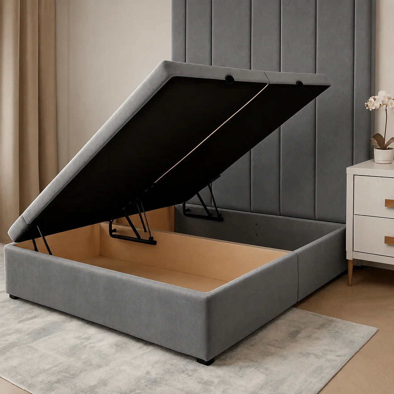 Grey upholstered storage bed with lift-up mechanism, showing spacious wooden interior, ideal for luxury bedrooms.