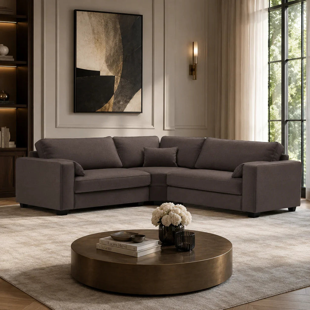 Luxury grey sectional sofa in modern living room with round coffee table and abstract art