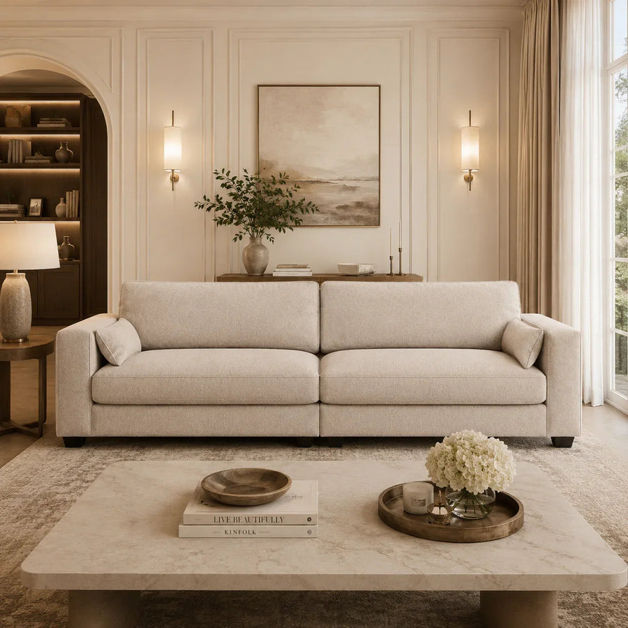 Luxury beige sofa in elegant living room with marble coffee table and warm lighting