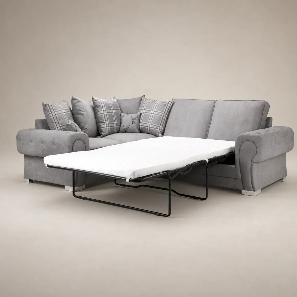 Grey fabric sofa bed with pull-out mattress and plaid cushions, ideal for living room comfort.
