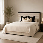 Luxury upholstered bed with tufted headboard, cream quilted bedding, and black accent pillows in modern bedroom